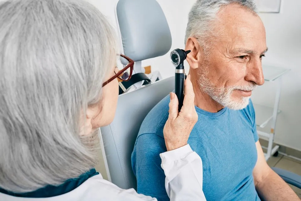 Doctor examining a patient's ear for tinnitus treatment at a clinic in Australia